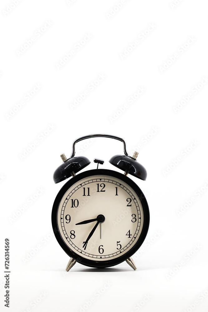 A black alarm clock with two bells on top, chrome handle, and legs, set against a white background. Timeless design meets functionality in this sleek, monochromatic timepiece.. A black alarm clock with two bells on top, chrome handle, and legs, set against a white background. Timeless design meets functionality in this sleek, monochromatic timepiece..