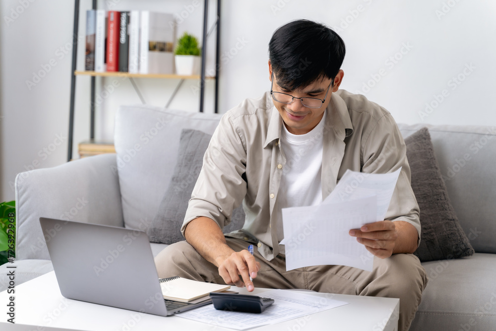 Man is calculating annual tax with calculator and filling form of Individual Income Tax Return. Season to pay Tax and Budget planning concept.