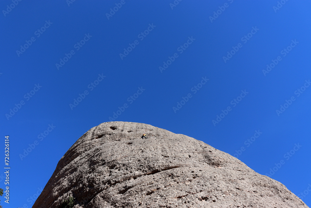 Einsamer Bergsteiger an einer runden Bergkuppe Einsamer Bergsteiger an einer runden Bergkuppe