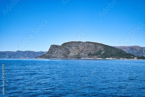 Western cap in Norway. A mountain reaching into the fjord. Blue sky. Landscape