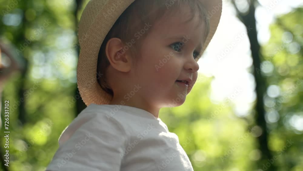 A little boy wearing a hat plays in a park. A little boy wearing a hat plays in a park.