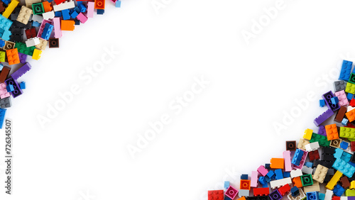 Close-up of cluttered piles of colorful toy bricks viewed from above with place for content or text. Isolated on white background, top view. Copy space. photo