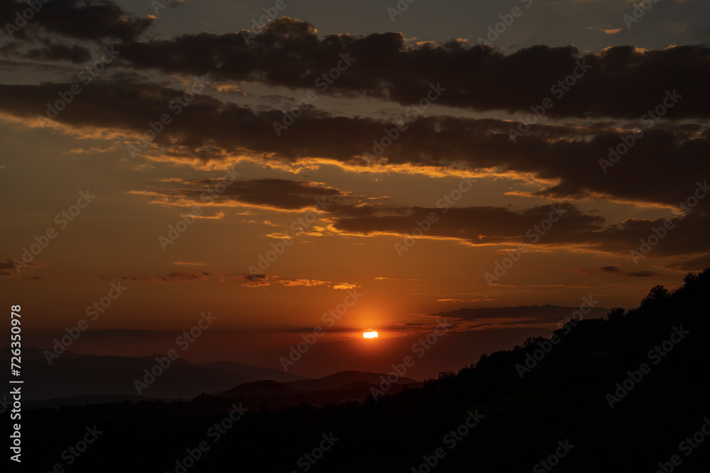 Beautiful sunset in the mountains. Sunset View from the Top of a Mountain. Sunset in strong orange tones in Serbia. The sun falls for horizon, a sunset. Shadows are condensed, beautiful clouds. Beautiful sunset in the mountains. Sunset View from the Top of a Mountain. Sunset in strong orange tones in Serbia. The sun falls for horizon, a sunset. Shadows are condensed, beautiful clouds.