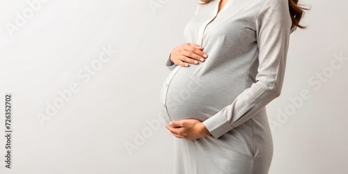 closeup of pregnant woman touching belly isolated on white