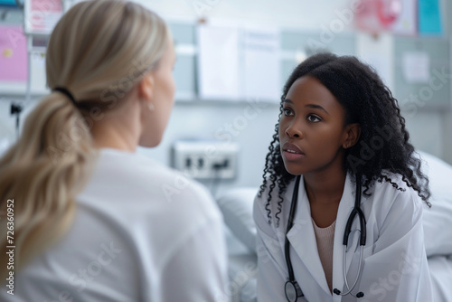 a black female doctor sitting in a ward and listening attentively to a patient complaining about her illnesses, the concept of patient care, promoting a healthy lifestyle photo