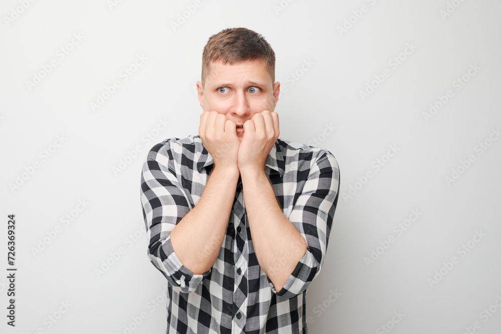 Portrait of guy with sad face worried, biting nails on white background. Nerves, stress, uncertainty concept. Portrait of guy with sad face worried, biting nails on white background. Nerves, stress, uncertainty concept.