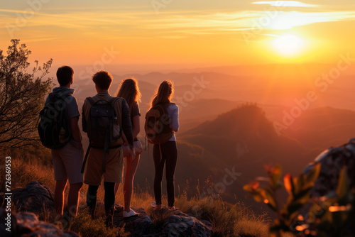 Group of people enjoying beautiful landscape on the mountain at sunset. Travel, holiday concept