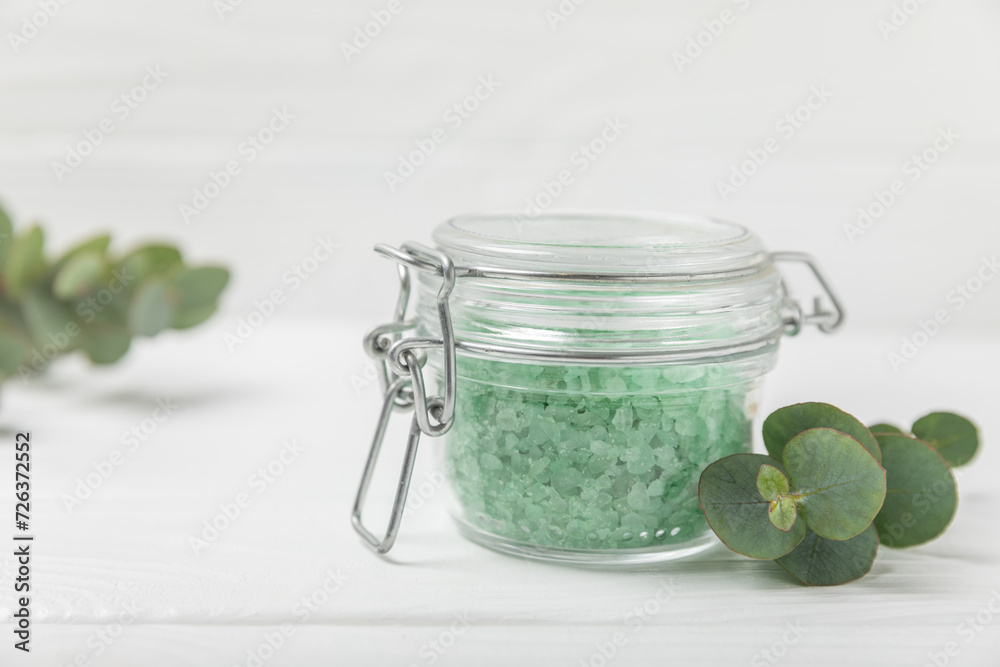 Cosmetic sea salt with aroma and eucalyptus extract on a textured wooden background with branches of fresh aromatic eucalyptus.Spa concept. Bath salt. Close-up. Space for text.Body care.copy space Cosmetic sea salt with aroma and eucalyptus extract on a textured wooden background with branches of fresh aromatic eucalyptus.Spa concept. Bath salt. Close-up. Space for text.Body care.copy space