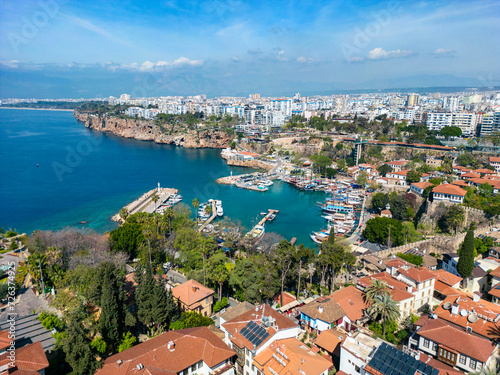 The bay in the city of Antalya from a height on a sunny day in Turkey. Beautiful view of the bay full of yachts and boats, and the ancient old castle. Photo from the drone