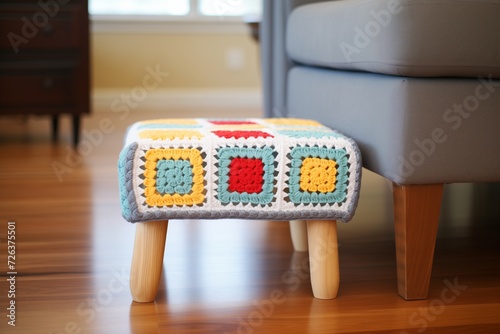 crocheted granny square footstool with wooden legs