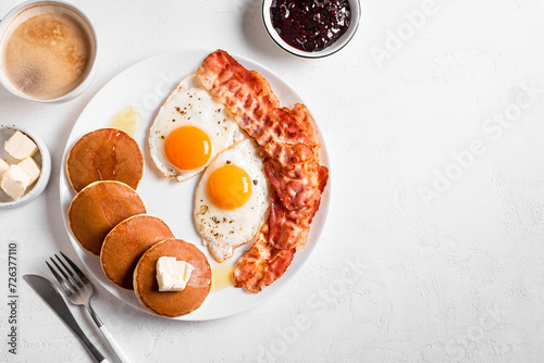 Breakfast with fried eggs, bacon and pancakes