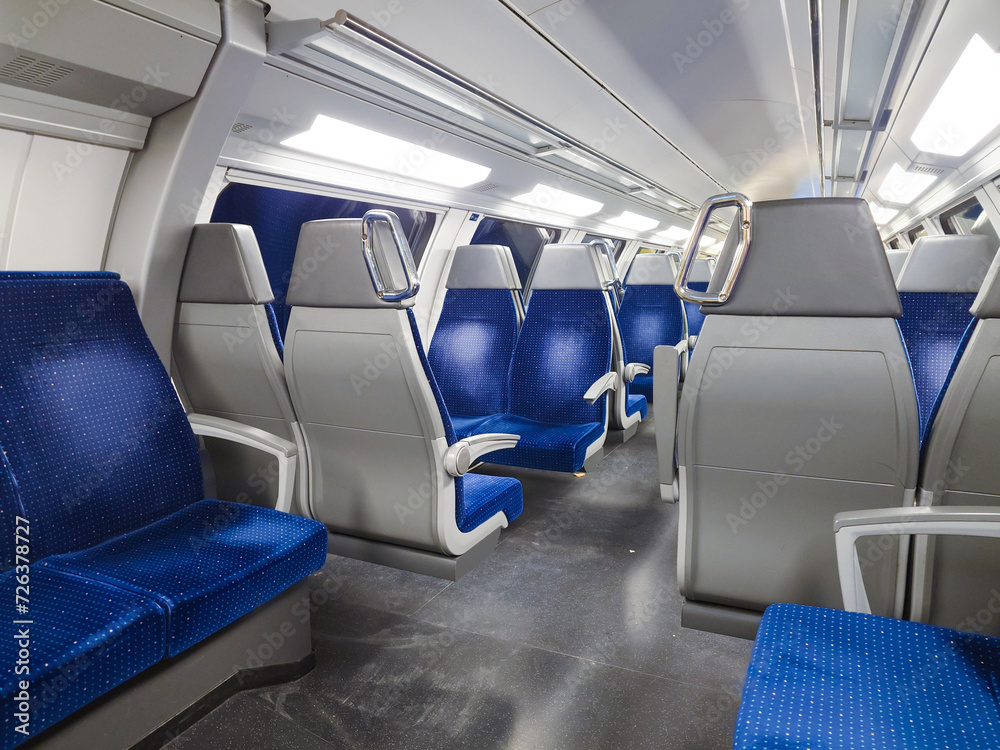 Empty chairs on the upper deck of a public transport train car. Blue chairs, interior lighting, no people, side chairs Empty chairs on the upper deck of a public transport train car. Blue chairs, interior lighting, no people, side chairs