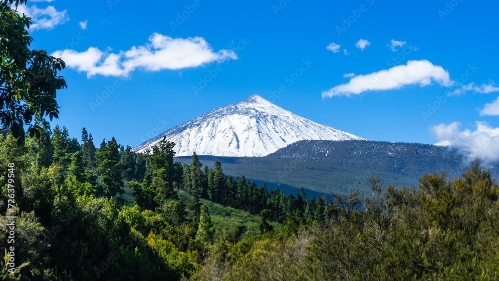 The peak Del Teide snow-capped with a blue sky and few white clouds. Tenerife, Canary Islands, Spain.