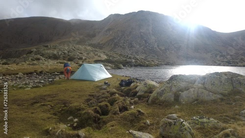 Timelapse of hiker pitching tent in the mountains