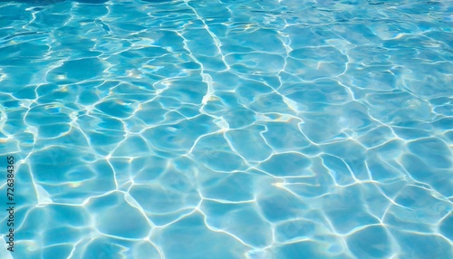 Clear water surface in swimming pool with ripples. Summer blue wallpaper.