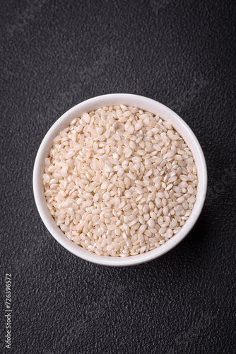 Large grains of uncooked white rice in a ceramic bowl