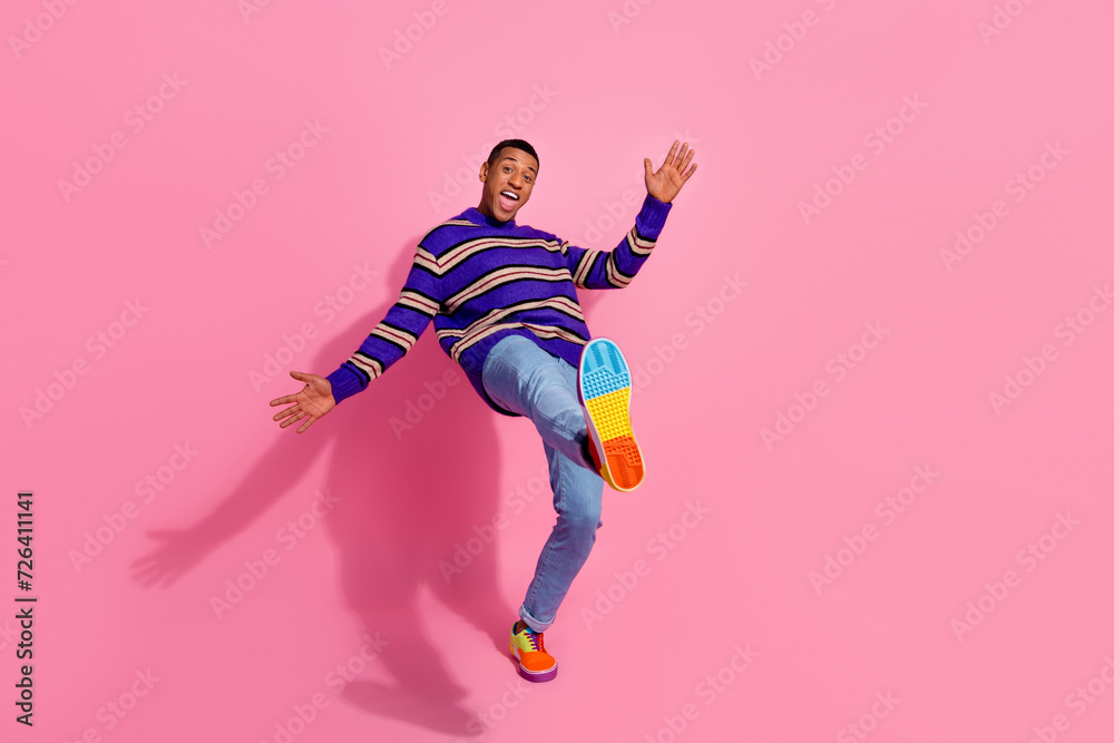 Full length photo of impressed cheerful guy dressed striped pullover walking empty space isolated pink color background