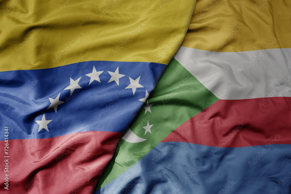 Fototapeta premium big waving national colorful flag of comoros and national flag of venezuela . macro