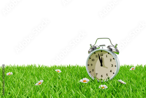 Alarm clock on a meadow in the grass. Daylight saving transitional change of season. 3d rendering photo