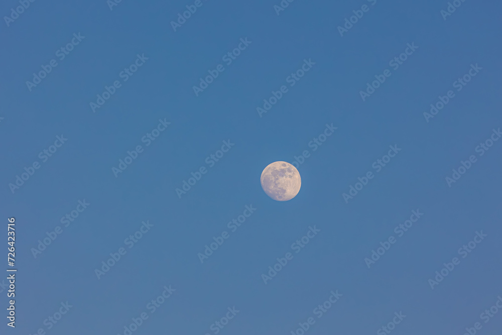 Natural phenomenon, Full moon in daytime with blue clear sky, A completely normal occurrence in astronomy is that the moon is directly opposite the sun in the sky, Nature background. Natural phenomenon, Full moon in daytime with blue clear sky, A completely normal occurrence in astronomy is that the moon is directly opposite the sun in the sky, Nature background.