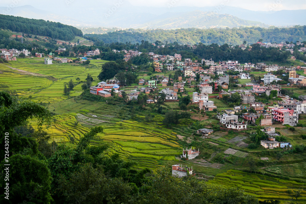 Blick auf den Stadtrand von der Hauptstadt Katmandu in Nepal von oben mit wenigen einfachen Häusern und Reis Terrassen Feldern dazwischen, Landwirtschaft und urbane Strukturen nebeneinander, Asien