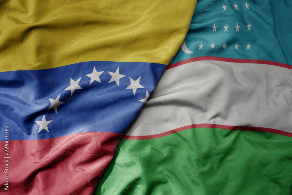 Fototapeta premium big waving national colorful flag of uzbekistan and national flag of venezuela . macro