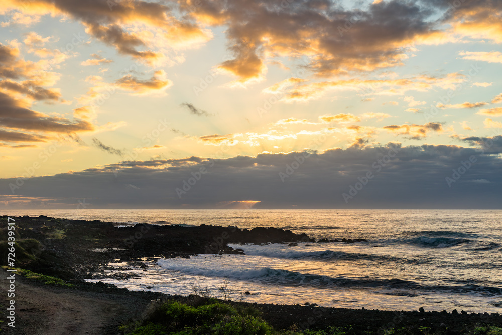 sunset with water refelction over the sea from the coast of the pacific on big island in hawaii