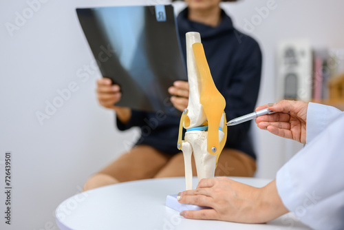 Obraz na płótnie An orthopedic surgeon demonstrates a knee bone model and explains the treatment of cruciate ligament injury using this model
