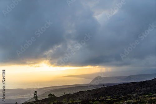 sunset over the volcanos with green plants on big island in hawaii