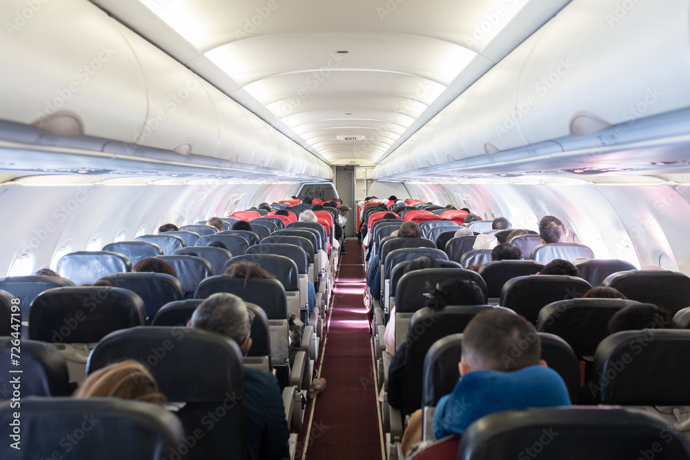 Fototapeta premium Passengers traveling by a plane, shot from the inside of an airplane