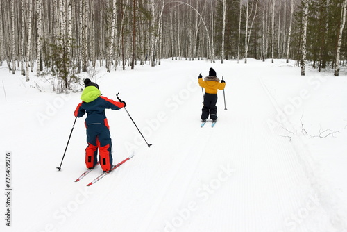 Children playing sports on a ski slope in the forest