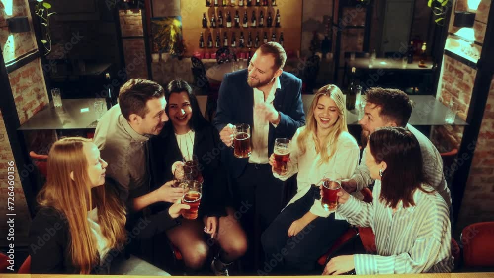 Saying toast and clinking glasses. Group of people, men and women meeting at pub, celebrating event, droning lager beer and having good time. Concept of leisure time, fun and joy, youth, enjoyment