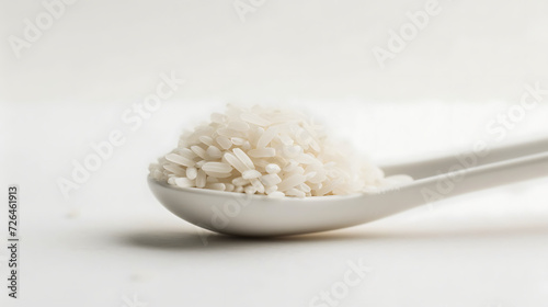 Clean measuring spoon of rice, plain white background