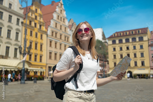 Woman with city map and smart phone. Fantastic view of the ancient homes on a sunny day. Gorgeous and picturesque scene. Location famous Market Square in Wroclaw, Poland, Europe. Historical capital of
