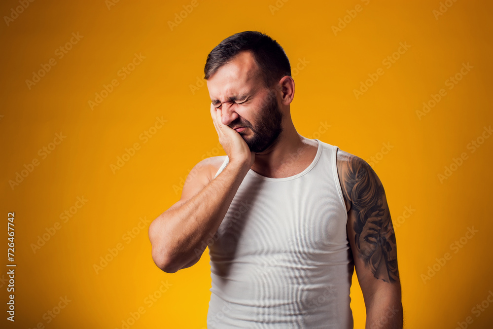 Man suffering from tooth ache. Hand on cheek. People, healthcare and medicine concept Man suffering from tooth ache. Hand on cheek. People, healthcare and medicine concept