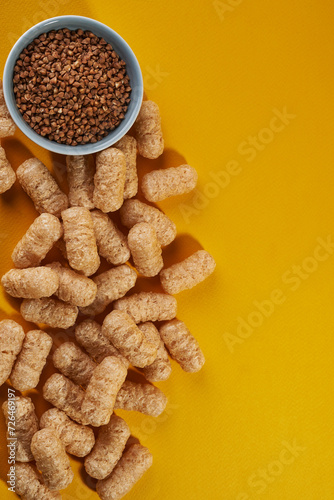 corn puffs with buckwheat on yellow background. top view