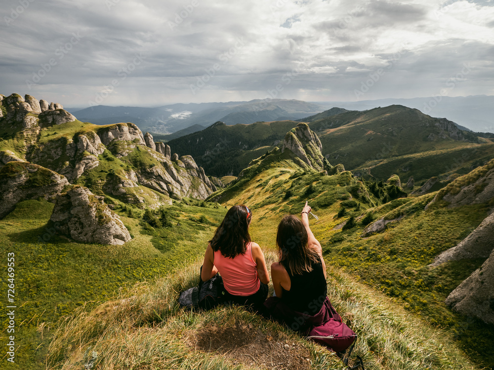 Girls enjoying the stunning view of alpine mountains in Transylvania