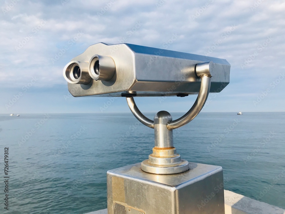 Touristic telescope stands on sea coast over blue sky background. Stationary binoculars with bill acceptor in the city of Batumi