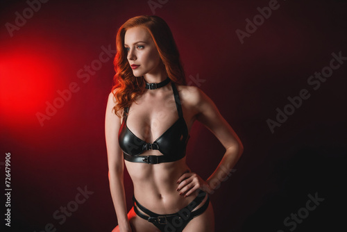 Young bdsm style red hair sexy woman portrait in black latex suit or lingerie. Generative Ai