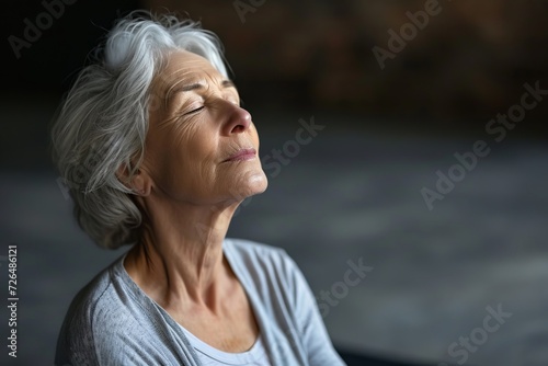 Close up Portrait of elderly woman sits in the lotus position meditating in a yoga studio. Mental and spiritual health development at any age