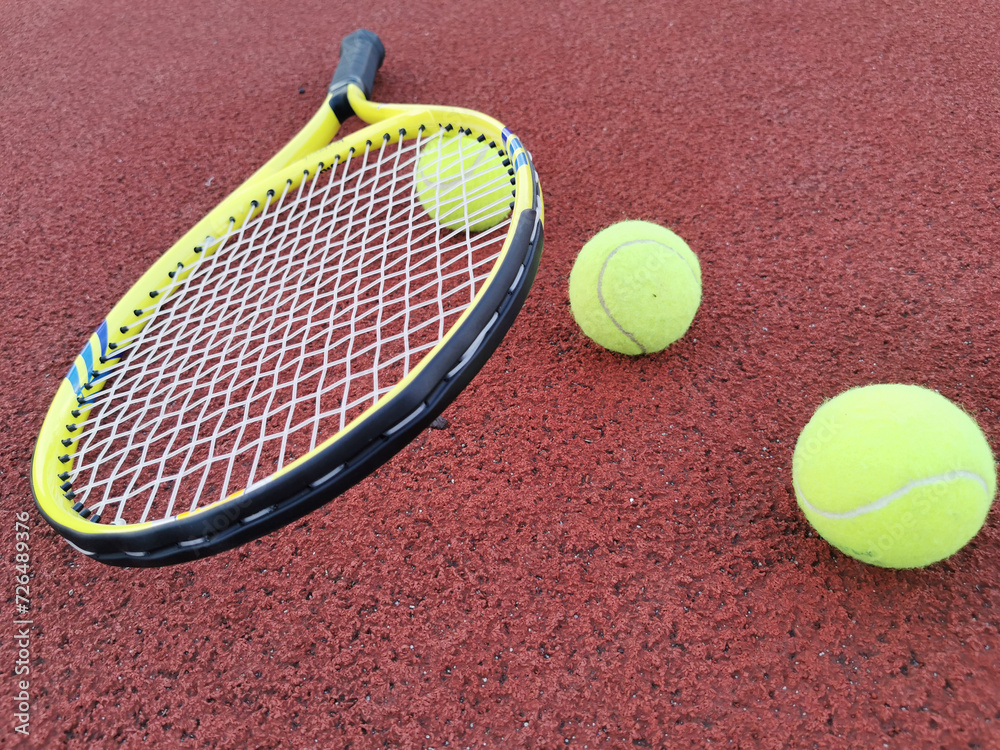  yellow tennis balls and racquet on hard tennis court surface, top view tennis scene