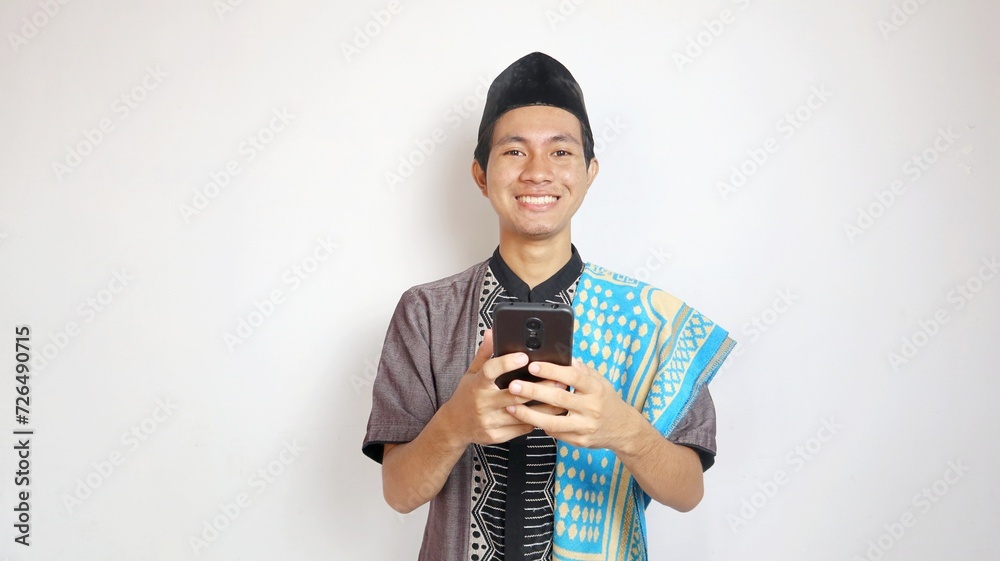 asian muslim man smiling with gesture holding playing typing smartphone asian muslim man smiling with gesture holding playing typing smartphone