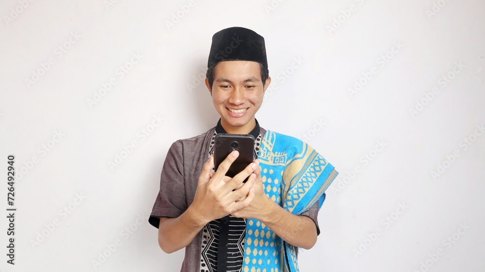 Excited Asian Muslim man is holding a smartphone Excited Asian Muslim man is holding a smartphone