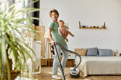 Foto man multitasking housework and childcare, curly father vacuuming apartment with