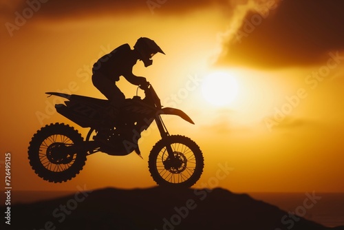 moto jumper silhouetted by setting sun