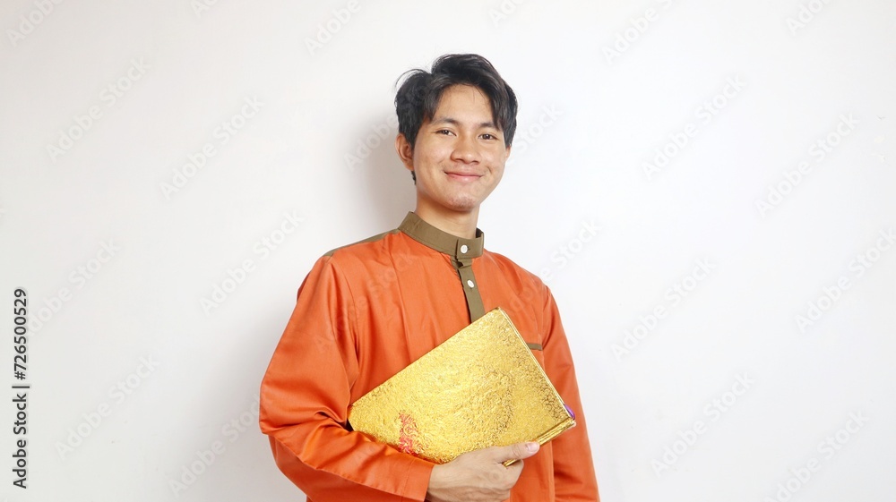 Asian Muslim man is holding al-quran Asian Muslim man is holding al-quran