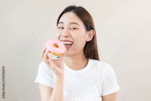 Beautiful joyful Asian young women eat sweet bakery isolated on background