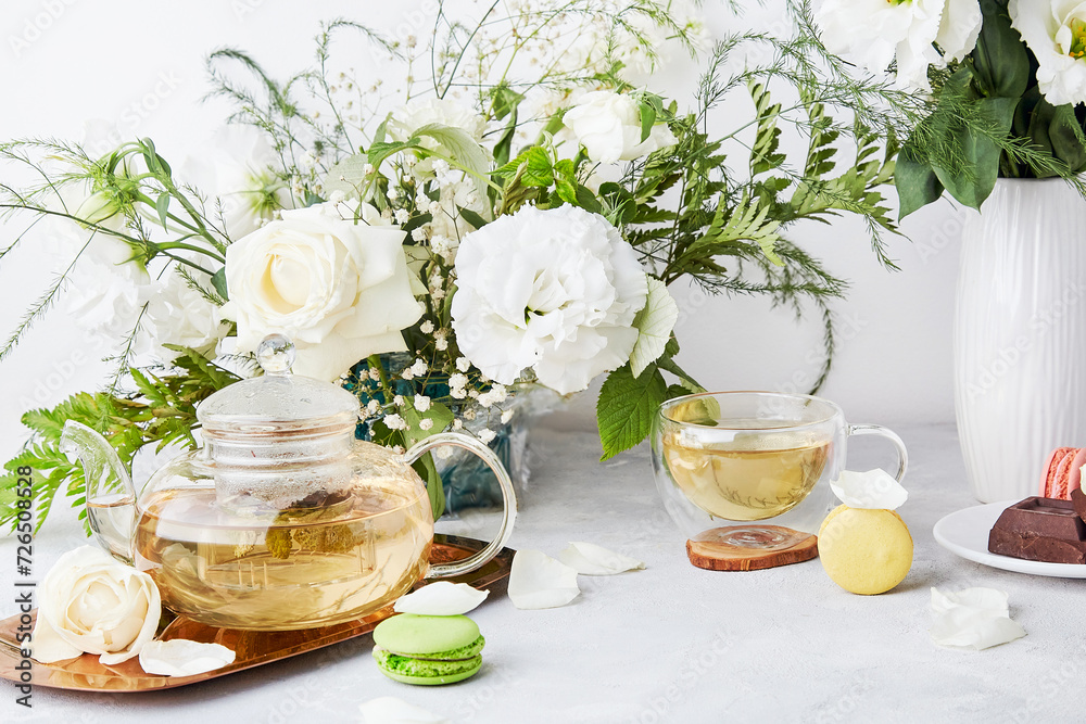 Aesthetic table setting. Green tea, macaroon desserts, chocolate, white bouquet - time for yourself, slow living concept. Aesthetic table setting. Green tea, macaroon desserts, chocolate, white bouquet - time for yourself, slow living concept.