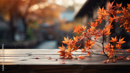 An empty wooden table top with orange leaves in autumn seasonal