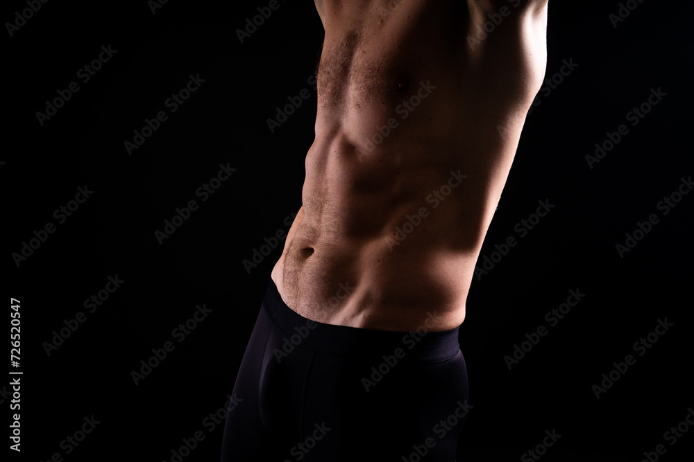 Handsome bodybuldier man posing showing muscle, shirtless torso showing pectorals and sixpack